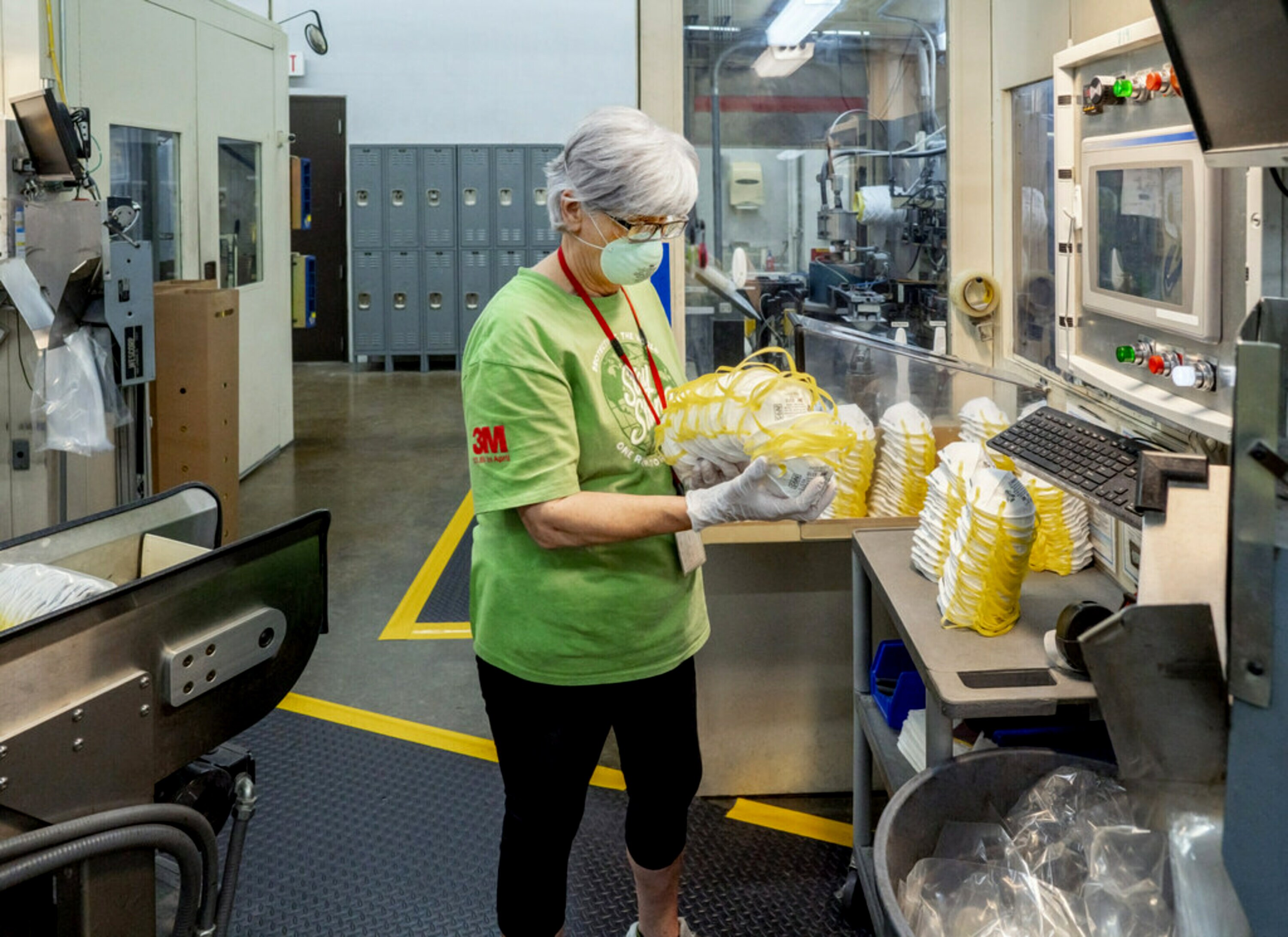 A woman in a manufacturing facility packaging 3M masks.