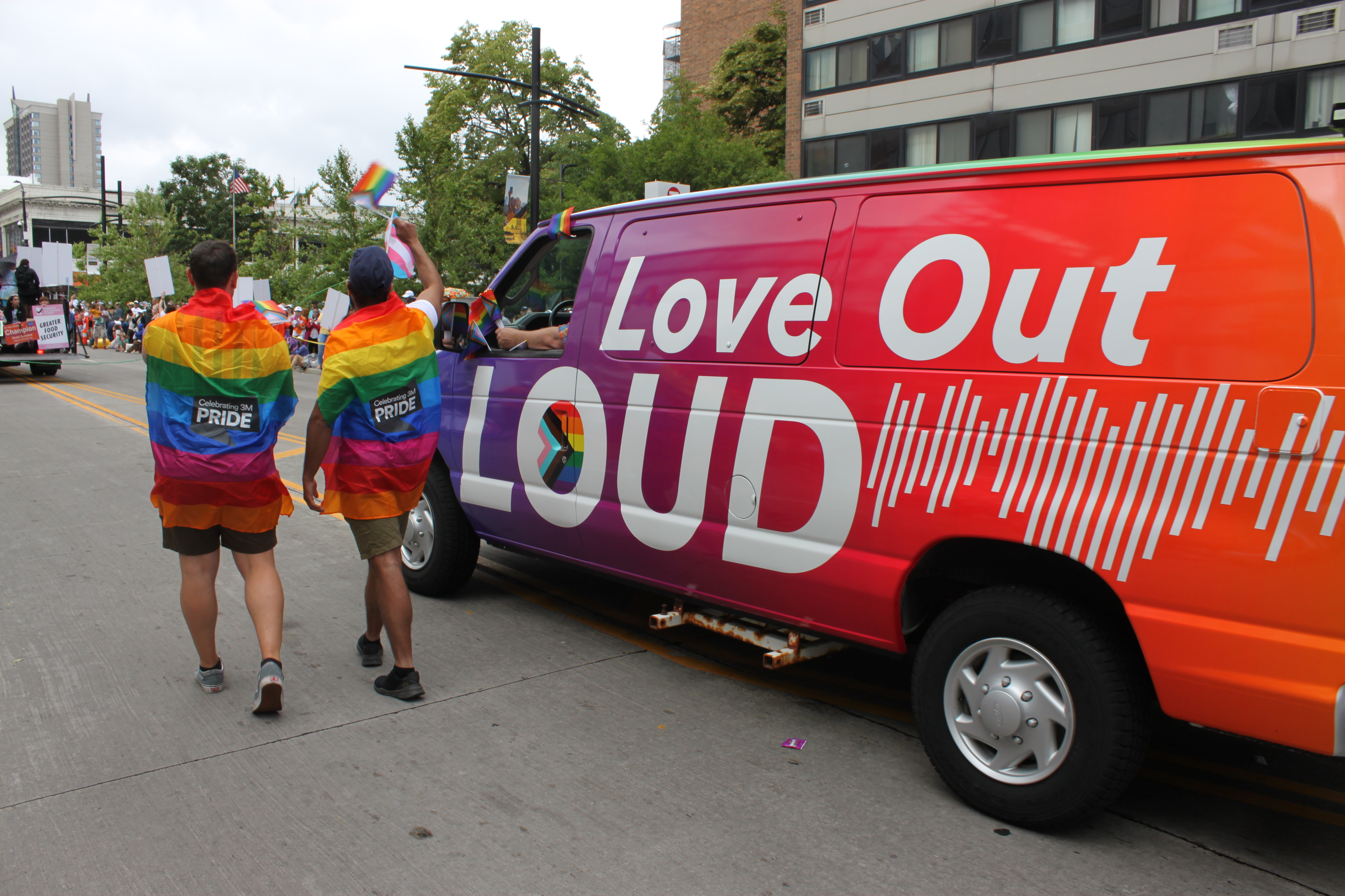 Image of 3M Van at 2023 Twin Cities Pride Festival with people waving flags. 