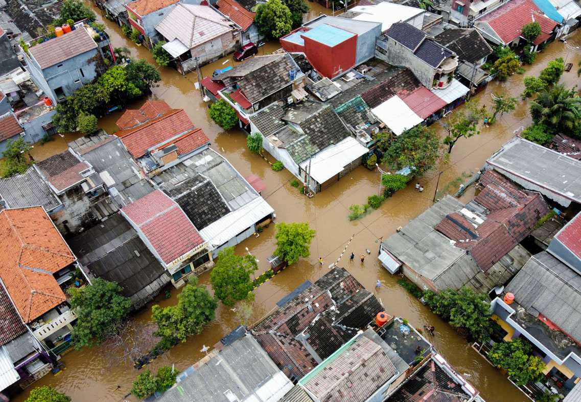 Aerial view of flooding with houses and trees surrounded by water.  