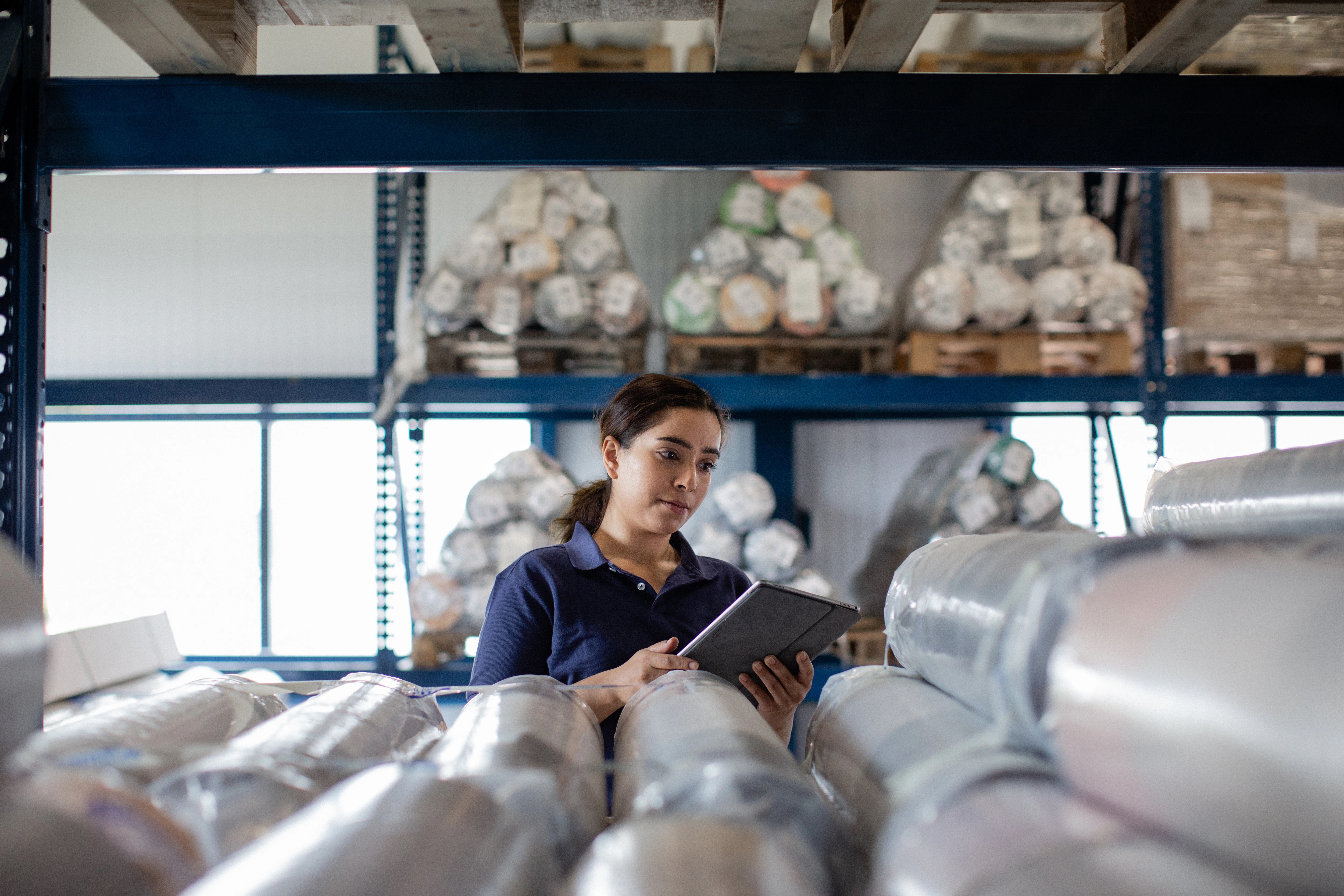 Woman working in distribution warehouse with digital tablet.